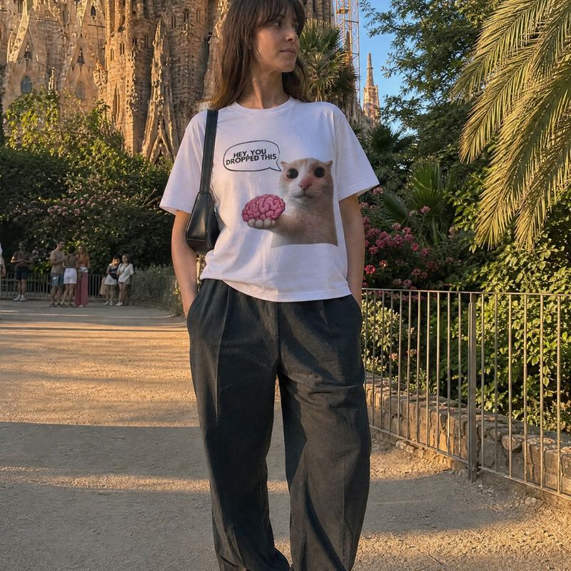 Someone on a path near the Sagrada Familia, wearing the white hey you dropped this tee.