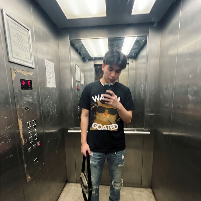 Someone in a lift wearing the goated tee.