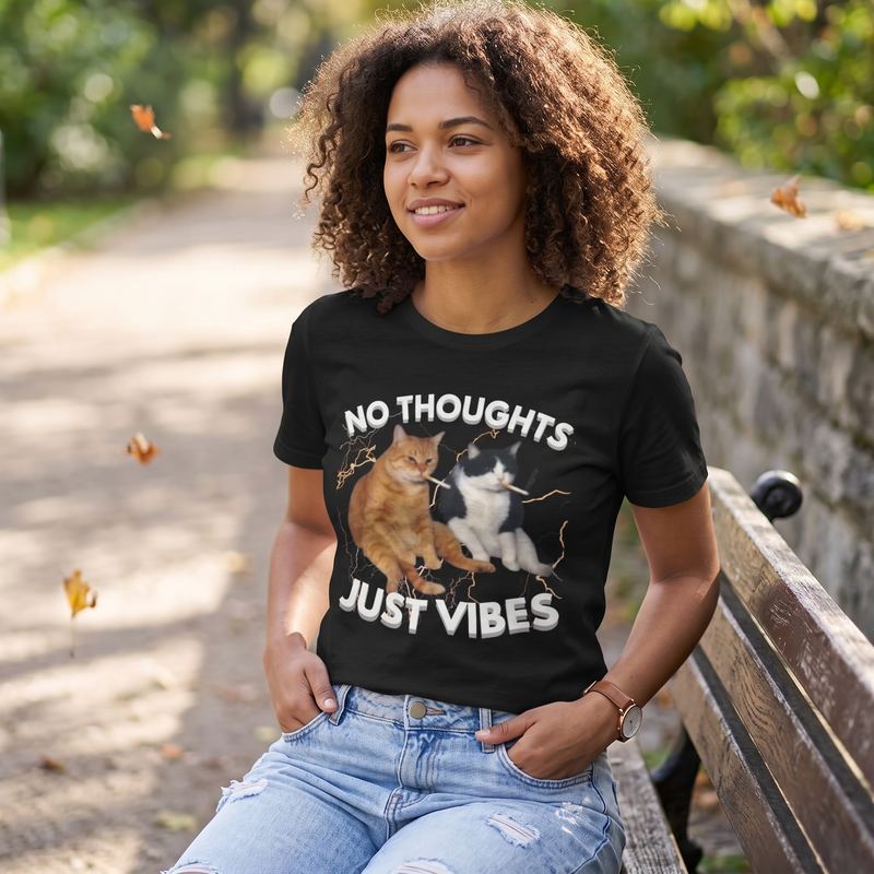 Someone sitting on a park bench in autumn, wearing the no thoughts just vibes tee.